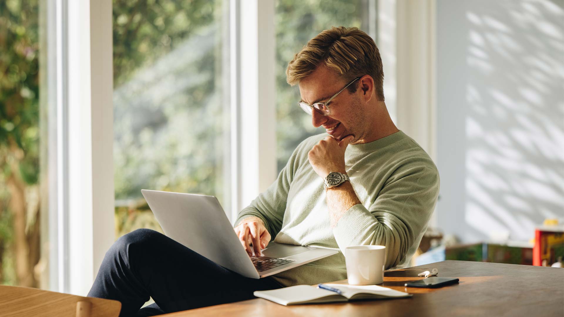 You man in his 30s looking at laptop.